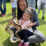 A little girl braving handling a snake